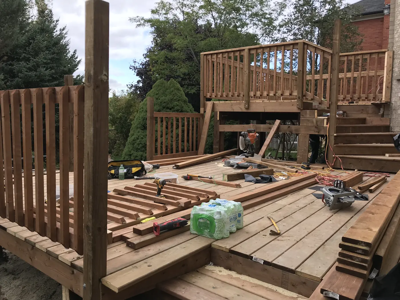 Two-level deck under construction with railings and stairs going in, Markham