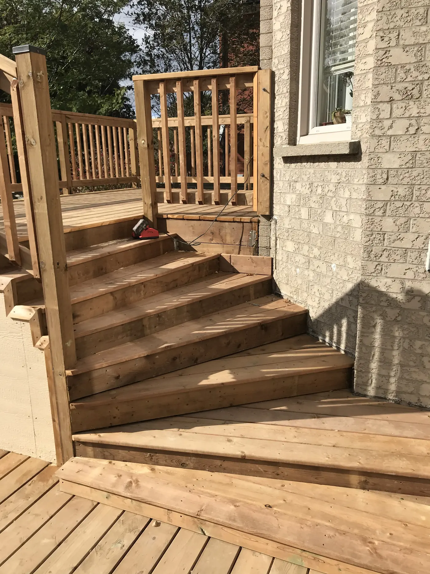 Wide pressure-treated stairs between two deck levels in Markham