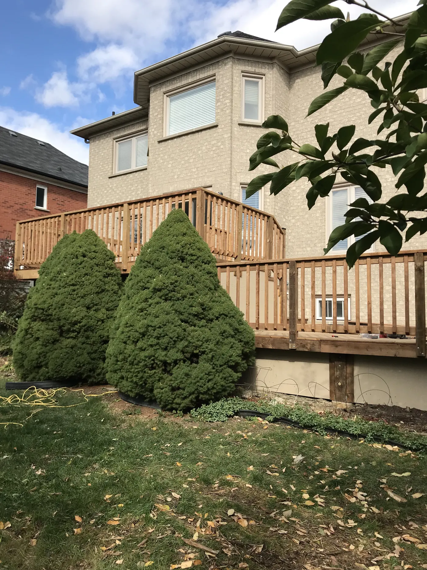 Two-level pressure-treated deck with wood railings on a Markham home, seen from the yard