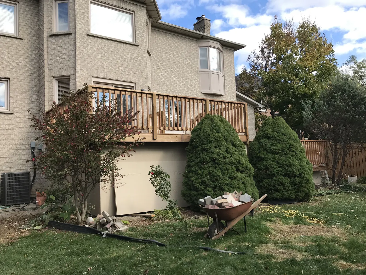 Side view of a raised two-level pressure-treated deck with skirting in Markham