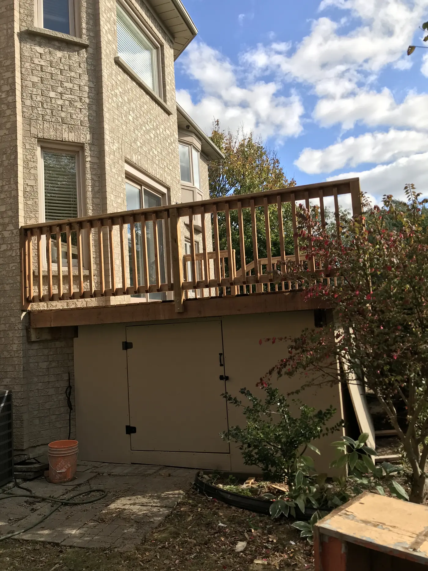 Raised upper deck with access doors to the space below in Markham