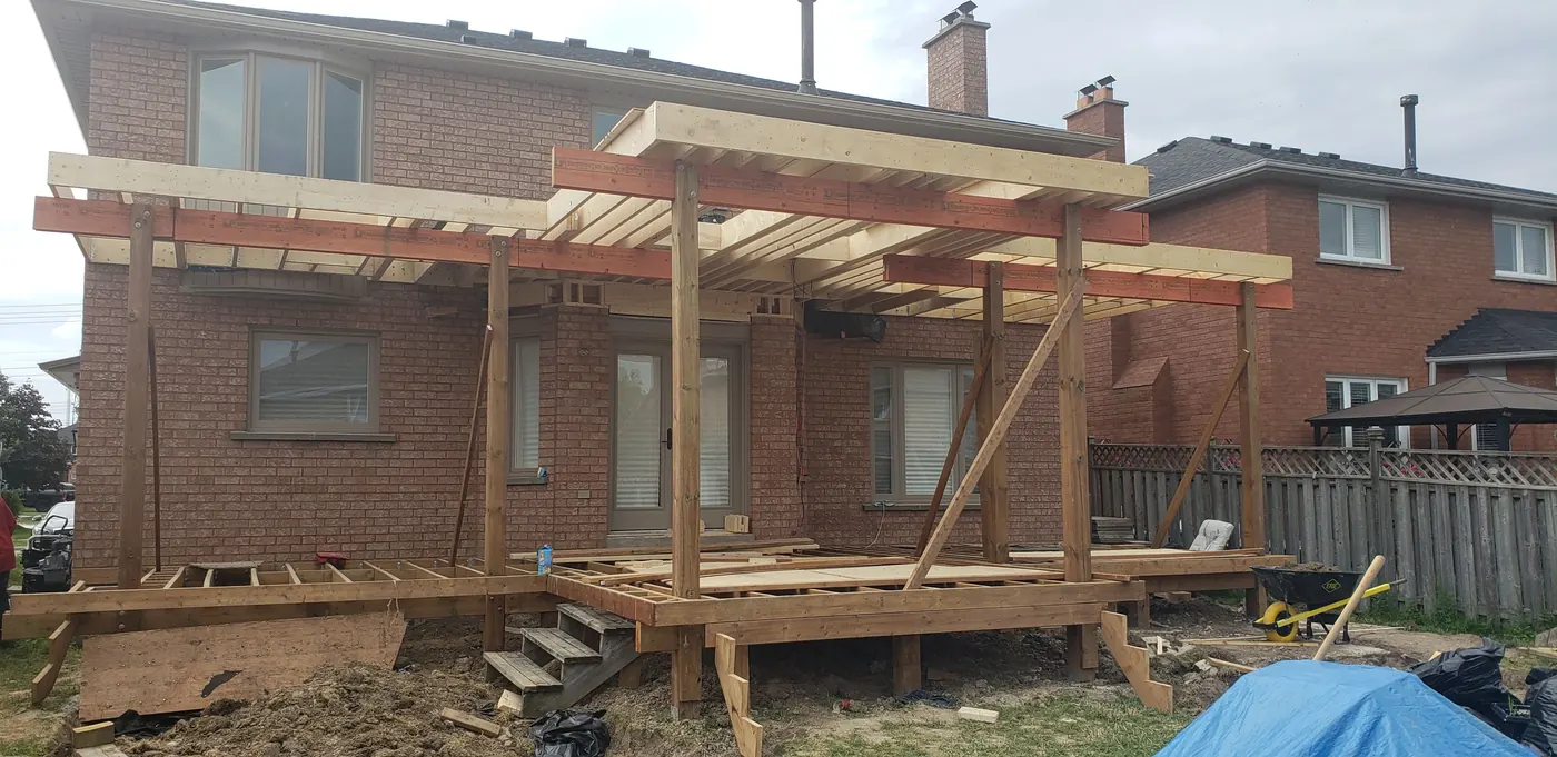 Deck framing with roof posts and beams going up in Vaughan