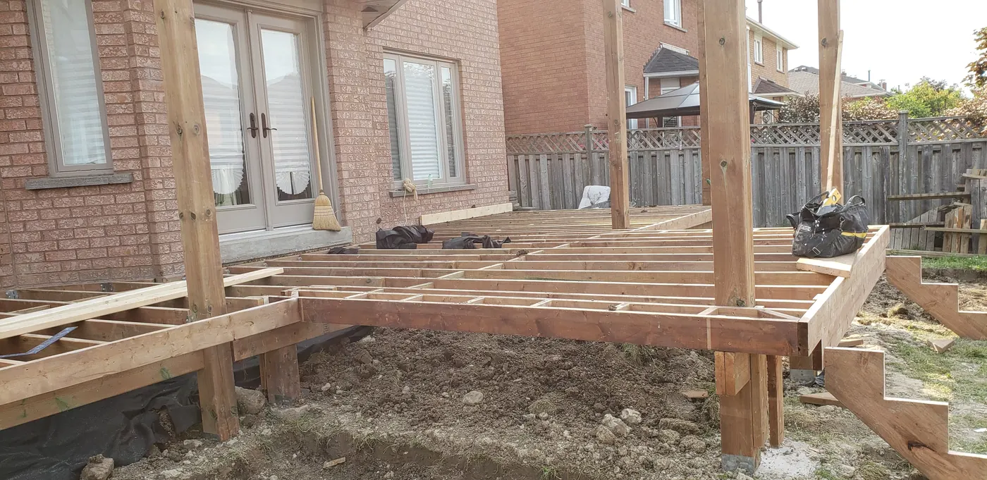 Pressure-treated deck joist framing on posts during a Vaughan build